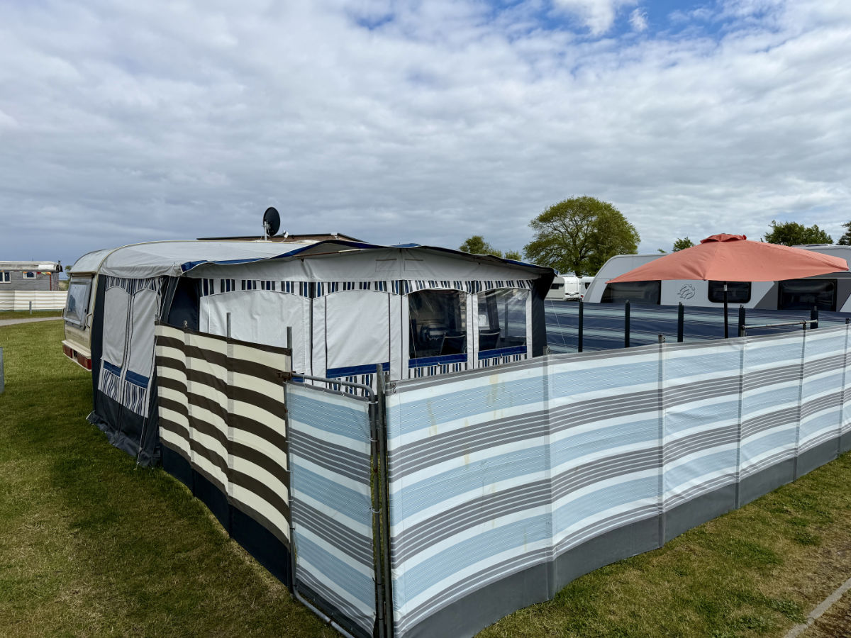 Vorzelt und Windschutz vor dem Mietwohnwagen auf dem Strandcampingplatz Dangast